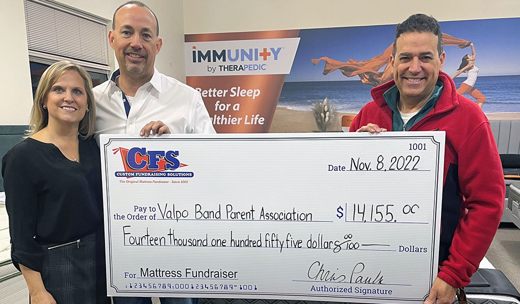 Three people from the Valpo Band Parent Association holding a cheque from the mattress fundraiser